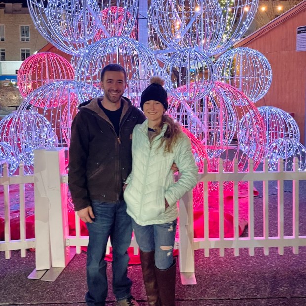 Couple standing in front of lighted ball Christmas tree at Market Square in Downtown Pittsburgh during Holiday Market