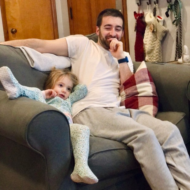 Father and daughter sitting on couch