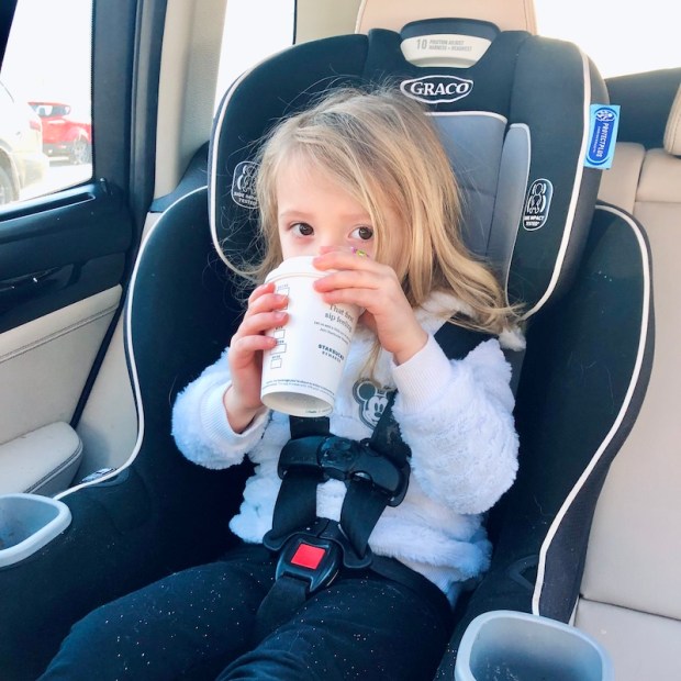 Toddler drinking Starbucks in carseat