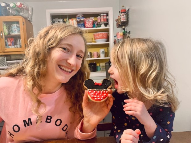 Mom and toddler holding Minnie Mouse cookies