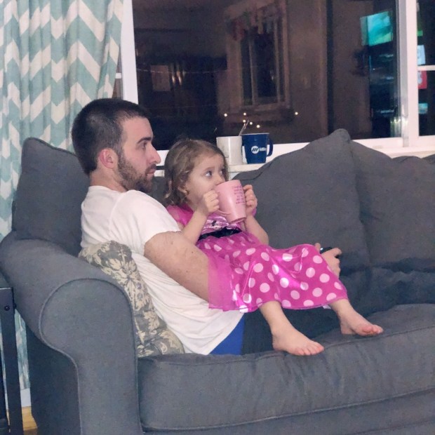 Dad and toddler sitting on couch together