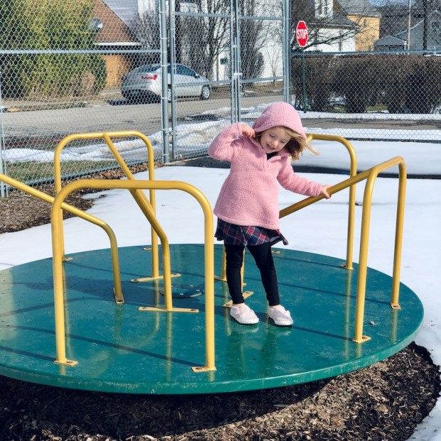 Toddler girl on spin wheel at park in Pittsburgh