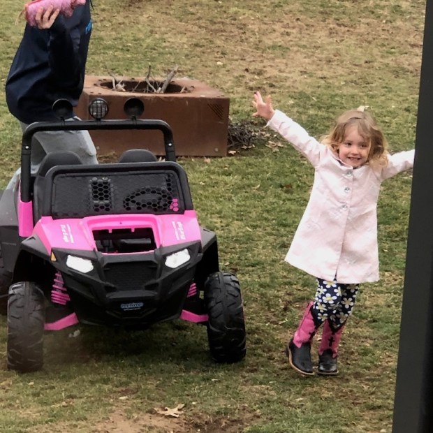 Toddler in pink coat by powerwheel
