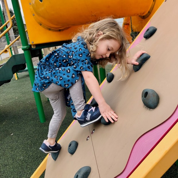 Toddler climbing rock wall