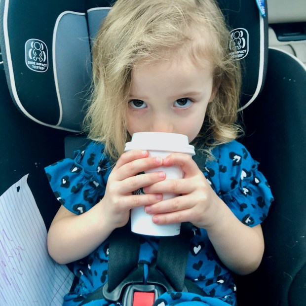 Toddler drinking Starbucks vanilla steamer in carseat