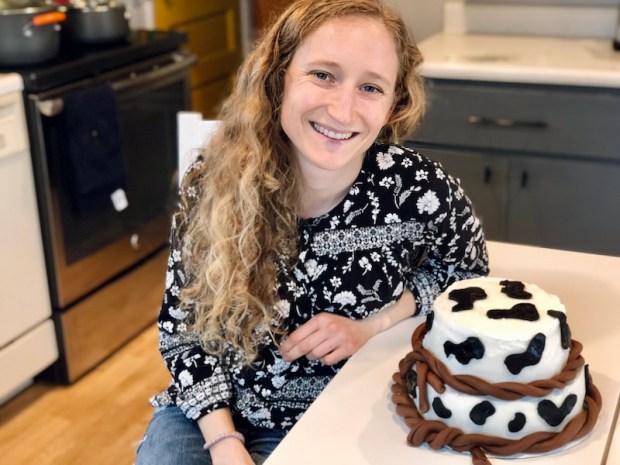 Baker with Western themed cow cake for birthday party