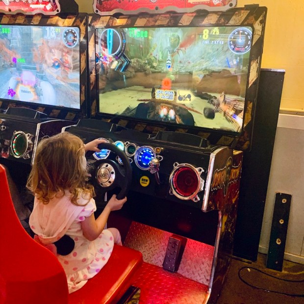 Toddler playing driving game at arcade in Outer Banks, NC