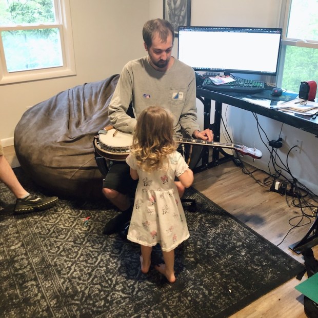 Guy showing toddler banjo