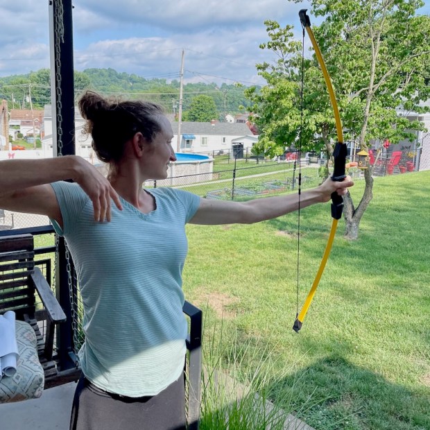 Girl shooting arrows with recurve bow