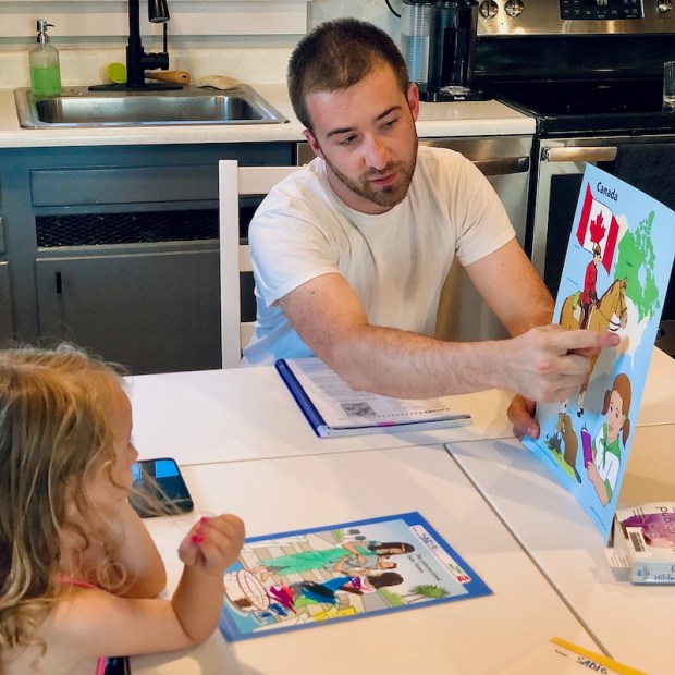 Dad teaching daughter homeschool lesson from Abeka