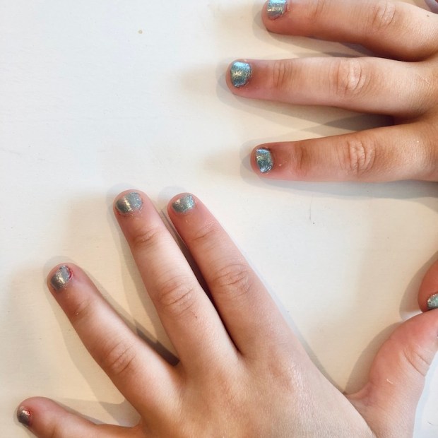 Young girl manicure with sparkly teal nail polish