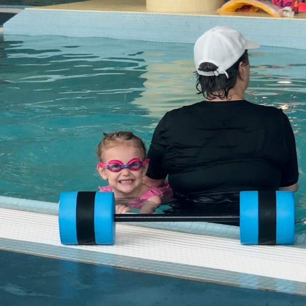 Young girl at swim lessons with goggles on