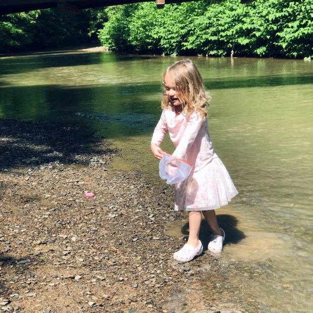 Young girl with net at creek