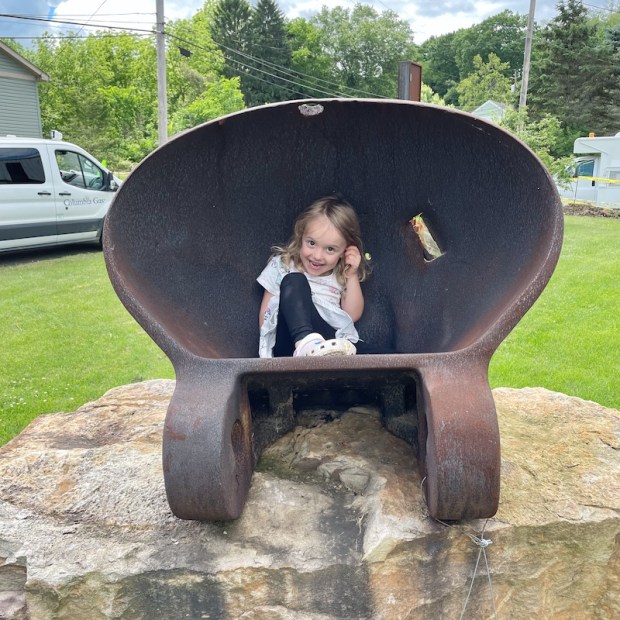 Girl sitting in giant construction bucket