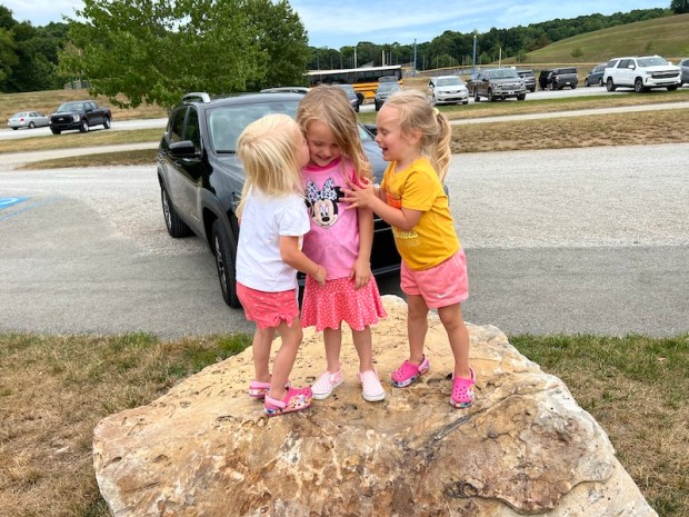 Cousins standing on a rock
