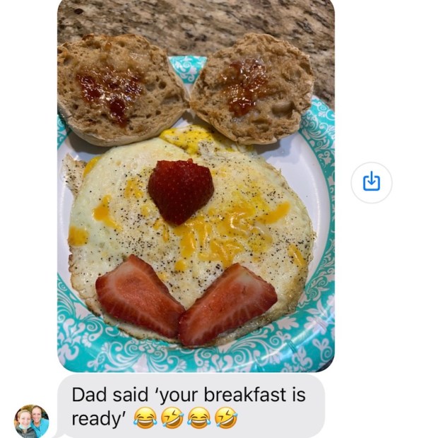 Funny breakfast face with eggs, English muffin, and strawberries