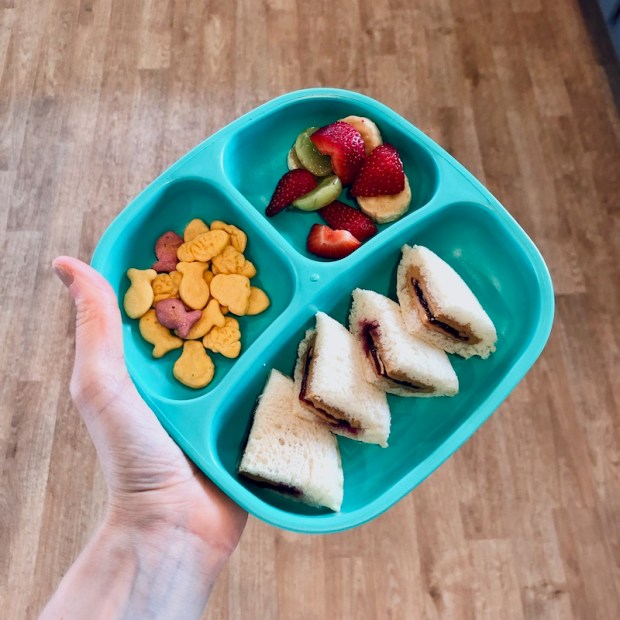 Re Play plate with peanut butter and jelly, Goldfish princess crackers, and fruit as lunch for child