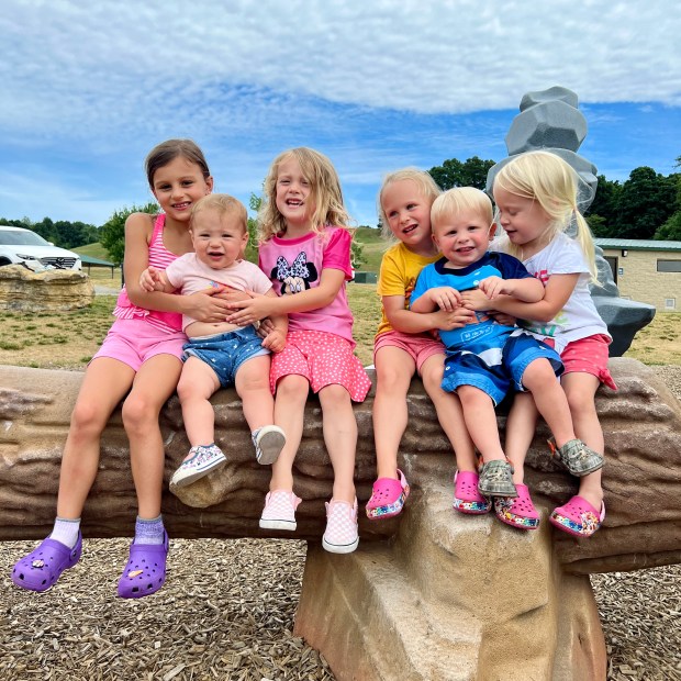 Group of kids sitting on a fake log at park in Pittsburgh, PA