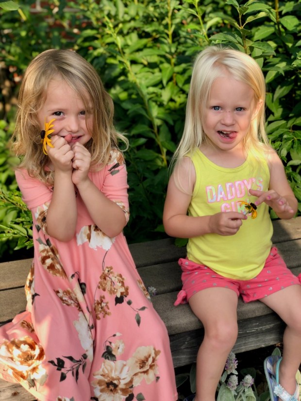 Two young girls sitting on a bench together