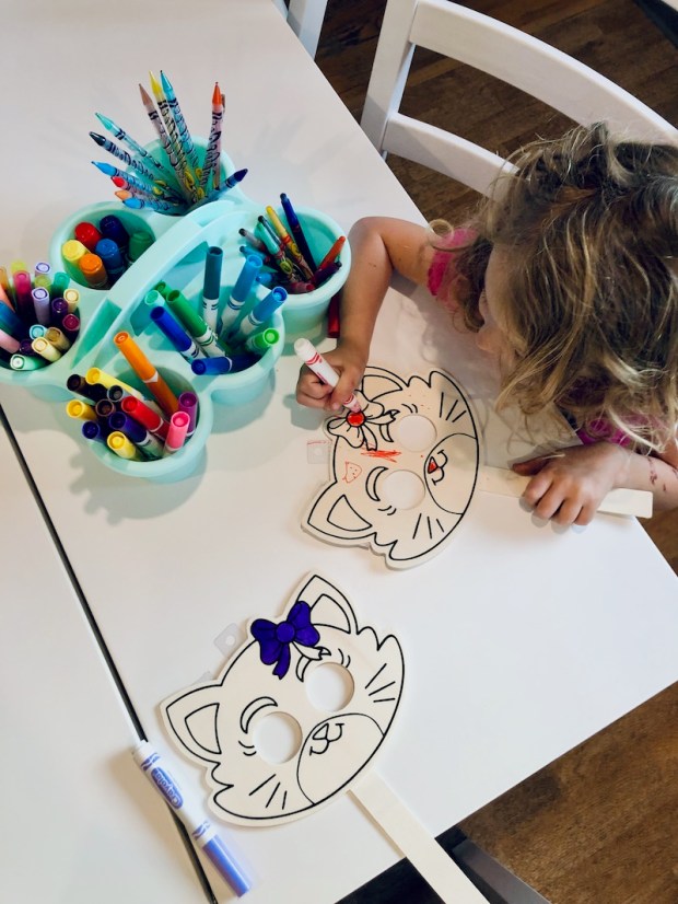 Mom and daughter coloring wooden cat masks