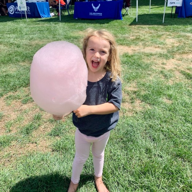 Child holding large pink cotton candy