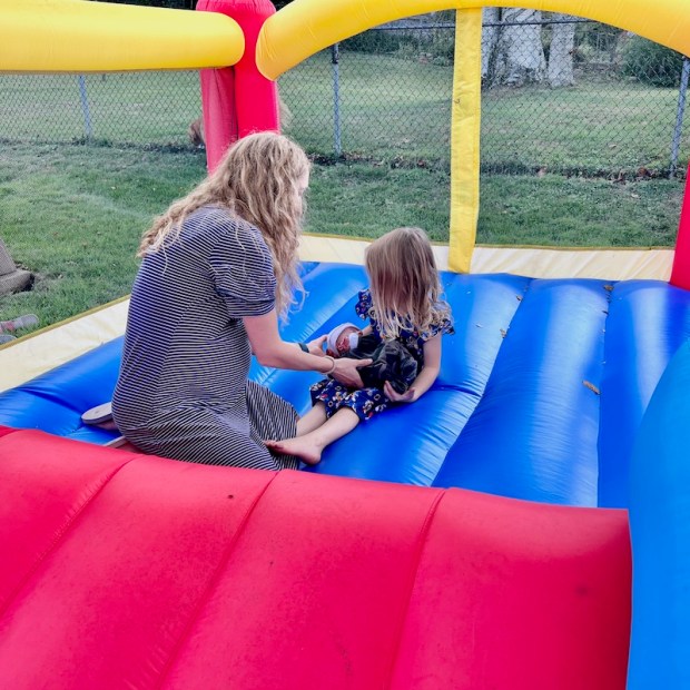 Girl holding four pound baby in bounce house