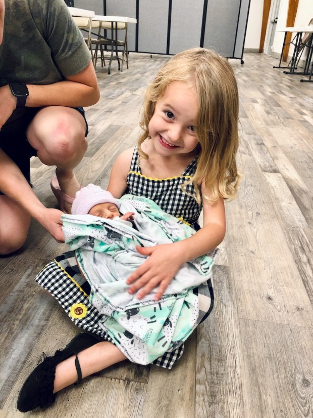 Young girl holding your pound baby