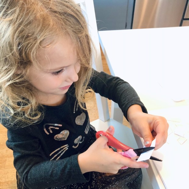 Preschooler learning how to use scissors