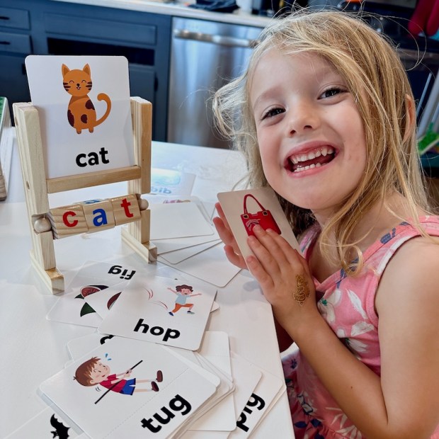Girl using Montessori spelling and reading toy from Amazon
