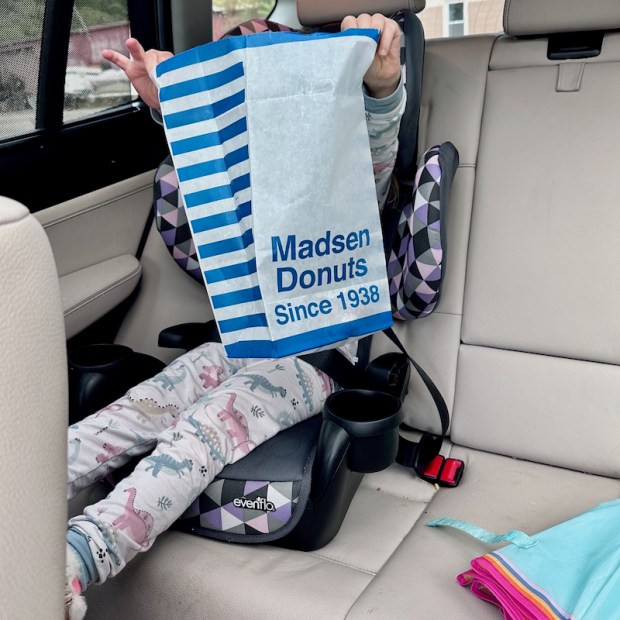 Girl holding Madsen Donuts bag