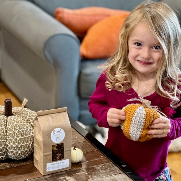 Girl holding crochet pumpkin
