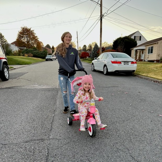 Mom pushing girl on bike 