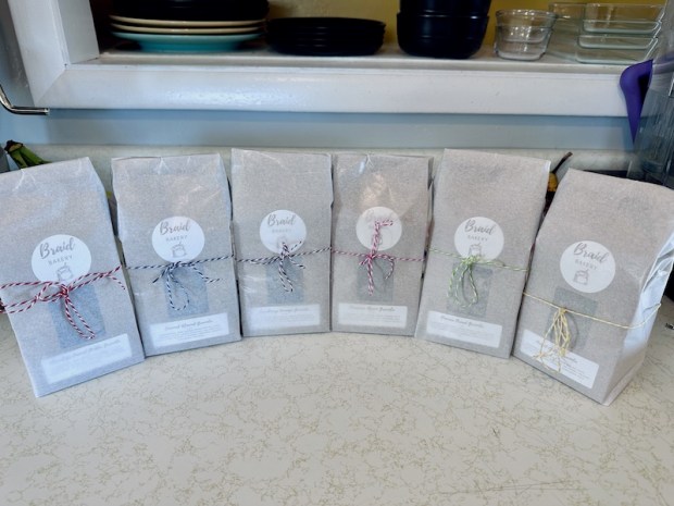 Bags of granola wrapped in tissue wrap with twine bows