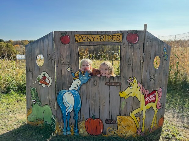 Girls in wood photo backdrop at corn maze