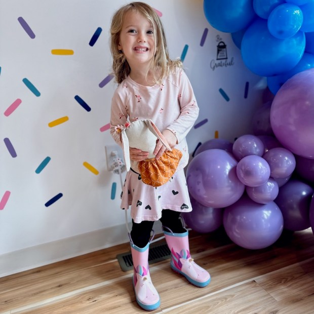 Girl standing by balloons in Sugar Butter Bakery in Carnegie