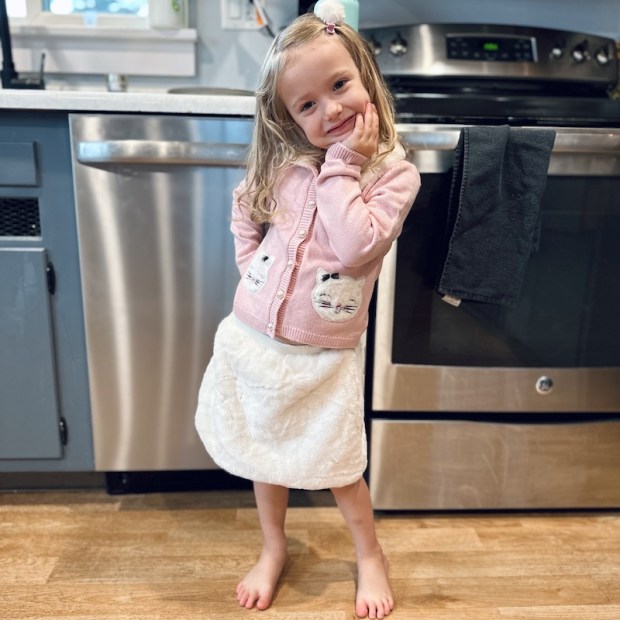 Girl wearing cat sweater and skirt set