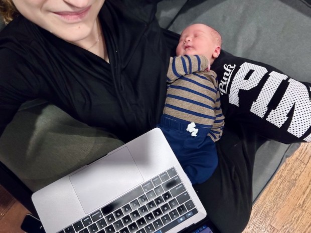Mom using computer with newborn on her lap