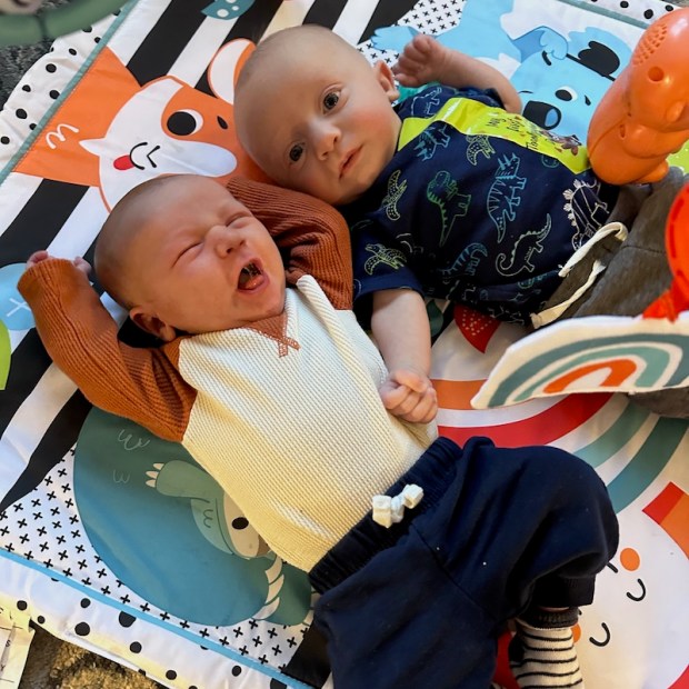 Newborn and three month old baby on play mat
