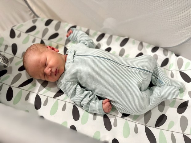 Newborn baby laying in bassinet