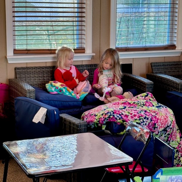 Three and four year old girls playing together on sun porch