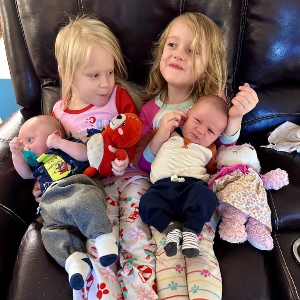 Preschool girls holding baby brothers