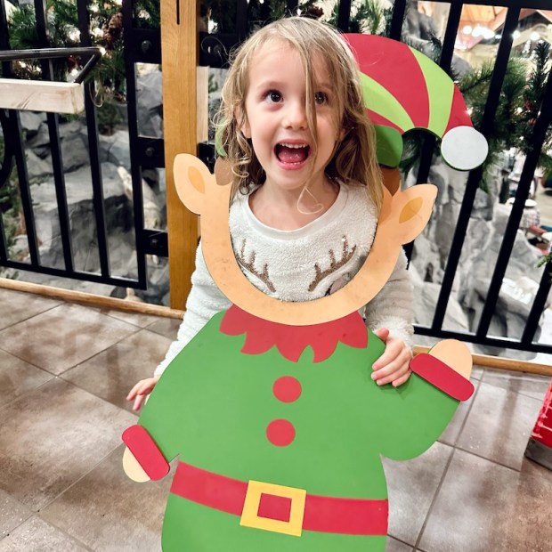 Girl standing in elf cut out at Cabela's before Christmas