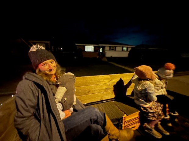 Girl on hayride with baby in carrier
