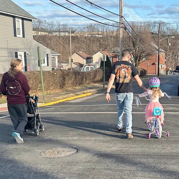 Family on a walk with girl on bike