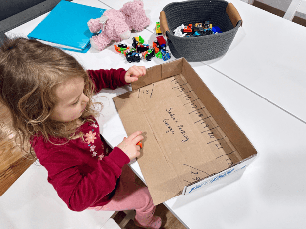 Young girl doing a car math activity to learn numbers
