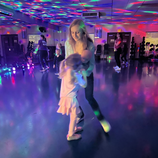 Mom, daughter, and son dancing with disco lights
