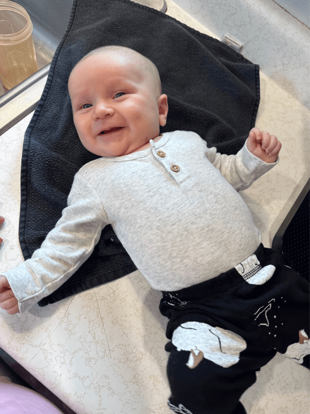 Baby boy laying on counter smiling
