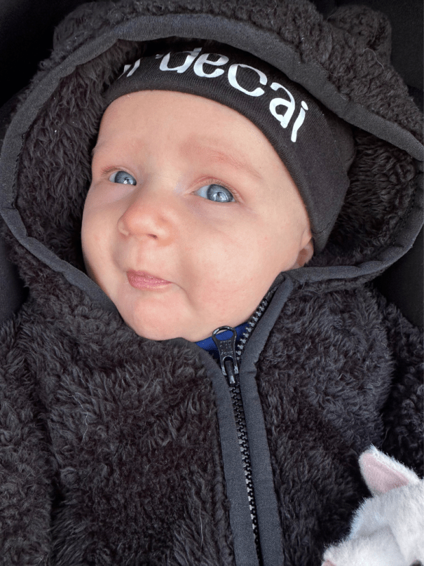 Baby boy with blue eyes in black bunting and hat