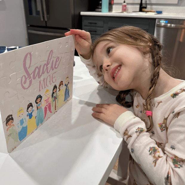 Girl with braids holding personalized princess puzzle