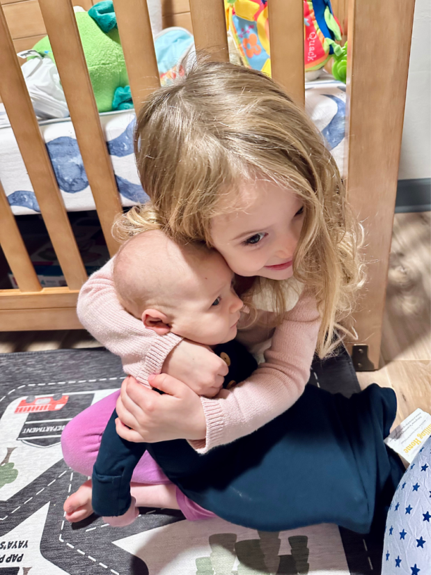 Older sister hugging baby brother